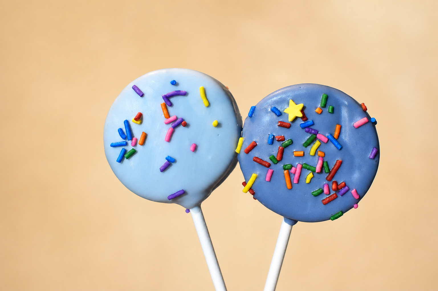 Two real blue cake pops made by Yared with colorful sprinkles and a star